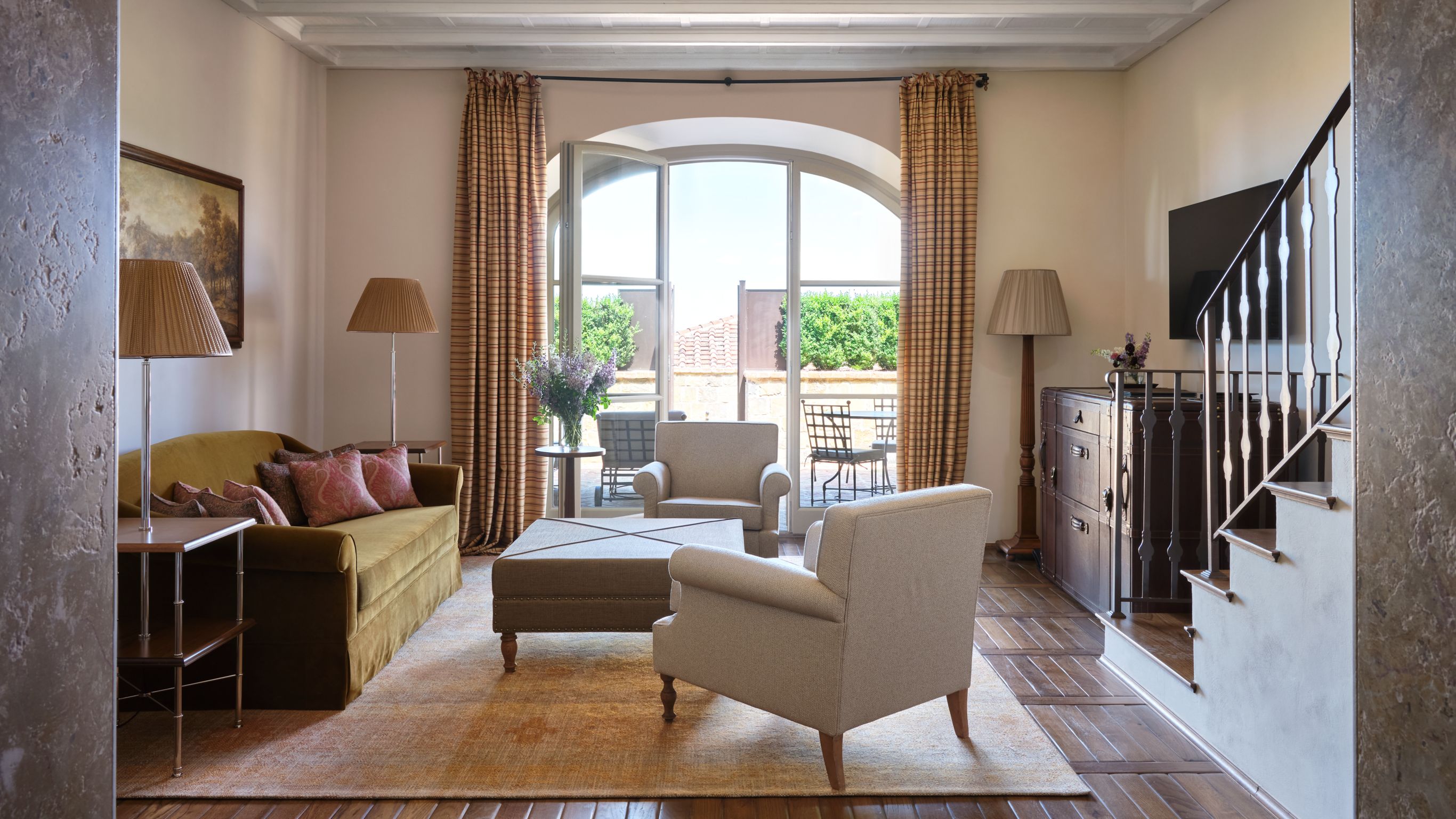 Living room with sofa, armchairs, large  window, and staircase